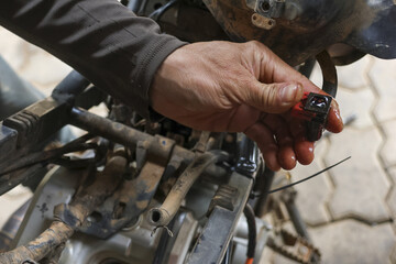 Close up of mechanic hand holding small, oily part, possibly from an engine, with determined and...