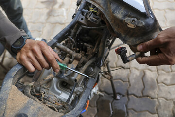 Mechanic meticulously repairs motorcycle engine with focused determination, showcasing hands on...