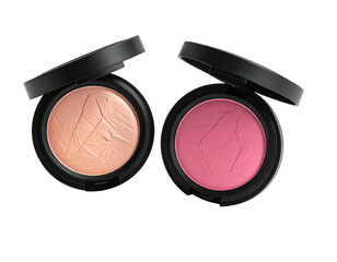 Two open compacts of powder makeup, one peach and one pink, black containers