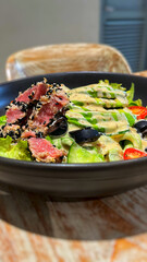 Fresh salad with seared sesame-crusted tuna and avocado slice