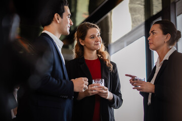 Group of professionals enjoying after-work drinks while discussing business opportunities or work or chitchat, showcasing trust, leadership, and collaboration.