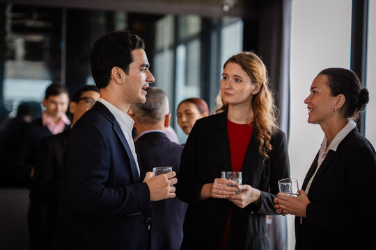 Informal gathering of professionals discussing strategies while enjoying a relaxed party environment. Businesspeople having conversation at informal meeting or event.