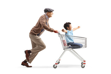 Grandfather pushing a boy inside a supermarket shopping cart