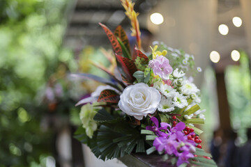 Vibrant and elegant floral arrangement, bursting with variety of colorful blooms and greenery, evoking sense of joy and natural beauty