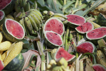 Huge pile of decomposing food waste, including cut red watermelon and green banana. concept of agricultural excess, leftover fruit, and organic compost material
