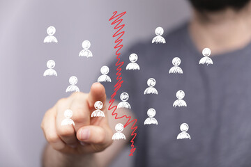 Image depicts a finger pointing at a dividing line separating group icons, symbolizing teamwork challenges, conflict, or loss.