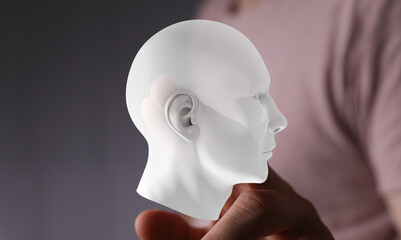 Digital human head model held in hand. AI, technology, future, innovation concept.