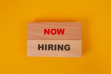 Top View Of Wooden Blocks With Now Hiring Words Over Yellow Background