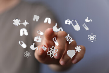 Person interacts with digital medical icons.  Healthcare, technology, innovation, medicine.