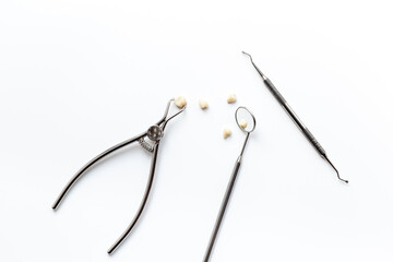 Many dental metal tools and teeth crows for implantation on white background. Professional Dentist desktop, top view