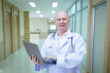 Hospital, healthcare, medical, doctor, nurse using laptop to review patient information, senior male mentoring young student trinee in hallway, technology helps improve teamwork efficiency diagnosis