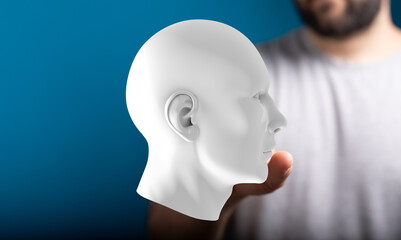 Abstract image of a man holding a 3D model of a human head, representing AI, technology, or mind.
