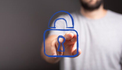 Man's hand interacting with a virtual padlock icon, symbolizing digital security, data protection,...