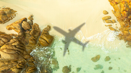 Aerial view of shadow passenger plane silhouette and sandy beach blue sea with waves at sea beach summer vacation sea travel concept	