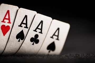 Four aces from a deck of playing cards are fanned out on a dark surface, symbolizing luck and winning in card games
