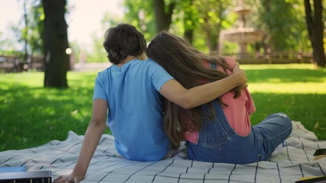 Teen couple in love hugging and planning future during romantic date outdoors