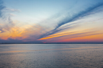 Beautiful sunset full of amazing natural colours seen over the North Sea during the summer solstice in Scandinavia, with the clouds creating a unique idyllic painting  with reflections in the ocean