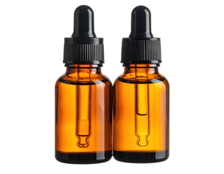 Two amber glass bottles with black droppers against a solid black background