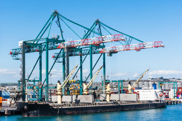 Cargo ship moored at the container terminal in San Antonio, Chile, under large gantry cranes.