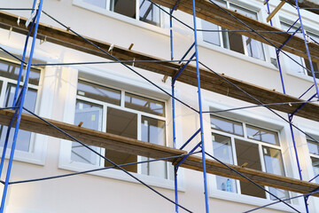 Obraz premium Building renovation in progress with scaffolding and workers preparing windows for installation