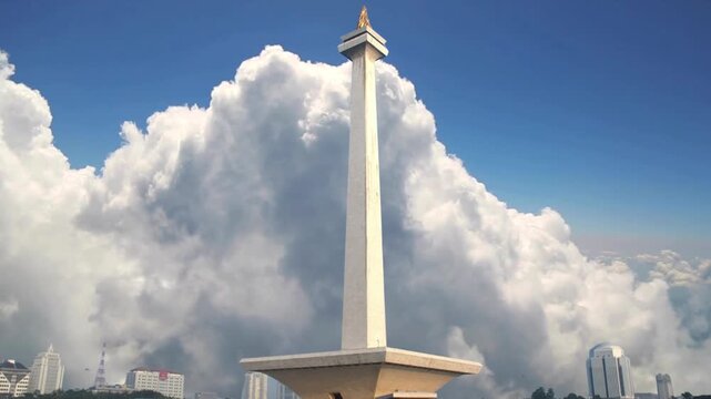 An imposing view of Jakarta's iconic obelisk, a national freedom monument, soaring into a dramatic cloudy sky