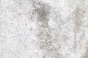 A rough, weathered, and stained white concrete surface, showcasing a mottled mix of gray patches that create a gritty, abstract background for industrial themes.