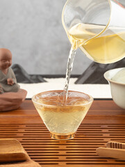 Pouring green tea into cup on table. Tea ceremony. 