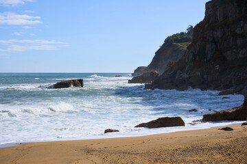 Ocean waves on coastal shore with cliffs