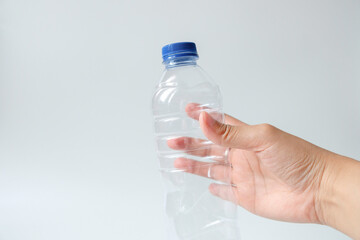 Hands holding plastic mineral water bottle trash on white background