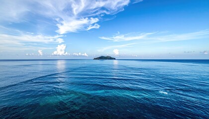 Fototapeta premium Seascape View of Deep Blue Sea with Distant Island Under a Partly Cloudy Sky