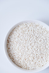 A bowl of white sticky rice grains isolated on white background