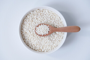 A bowl of white sticky rice grains isolated on white background