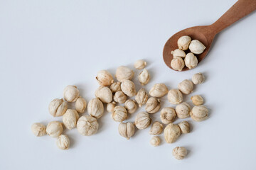 Dried white cardamom in a wooden spoon isolated on white background