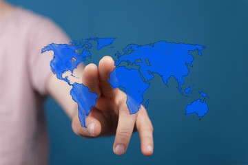 Hand interacts with a blue world map, symbolizing global reach, connection, and exploration.