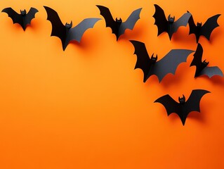 Fototapeta premium Black paper bats on orange background Halloween flat lay concept with ample advertising space, top view of flying bat silhouettes for horror festival poster, party promotion, and seasonal marketing.