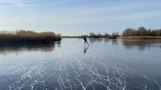 Point Of View ice skating on a frozen lake in nature during a beautiful winter day in Holland.
