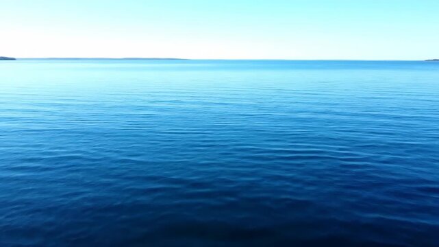 A wide, establishing shot captures the wind gently creating ripples and subtle waves on an open, expansive lake quiet, windy, environmental