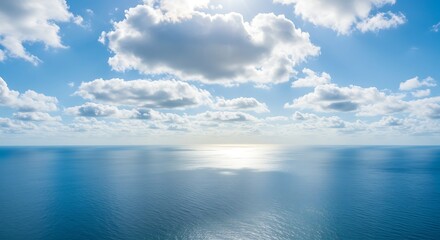 Obraz premium Aerial view of ocean horizon under a bright blue sky and white clouds