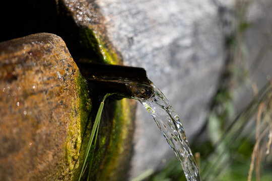 flusso d'acqua che scorre attraverso e fuori una piccola vasca in legno