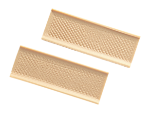 Two rectangular, beige objects, textured, lying at an angle against a black backdrop