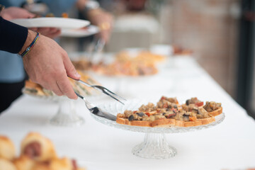 Attendees Select Delicious Appetizers From an Elegant Buffet Display at a Sophisticated Private Gathering Enjoying Culinary Delights