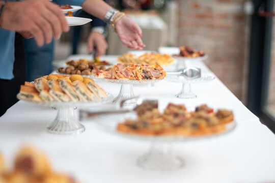 Guests enjoy a lavish buffet spread at a sophisticated private event offering a variety of delicious food choices displayed on elegant serving platters and stands for a delightful culinary experience
