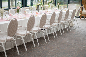 An elegant private event venue prepared for a celebratory lunch with a long table setting detailed with fine linens and floral arrangements
