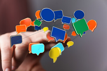 Digital speech bubbles connecting and floating above hand show communication network for social...