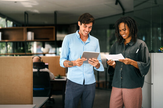 Fototapeta Two happy diverse multiethnic business team people working, talking in corporate office