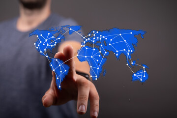 Person's hand reaching out to a glowing blue digital world map with a global network overlay, symbolizing worldwide connection, business, and te