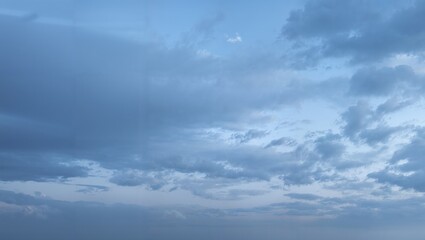 Fototapeta premium Serene expansive blue gray cloudy sky with layered clouds soft dawn light wide panoramic horizon calm overcast atmosphere subtle texture and gentle gradation of tones