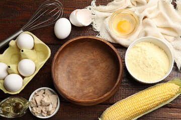 Making cornbread. Different ingredients and metal whisk on wooden table, flat lay