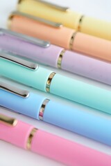 Fototapeta premium Pastel colored pens arranged neatly in a row for artistic and creative writing and drawing projects