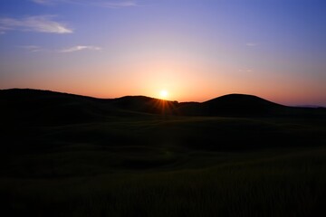 Sunset over the hills creates a beautiful and dramatic landscape with a colorful sky view